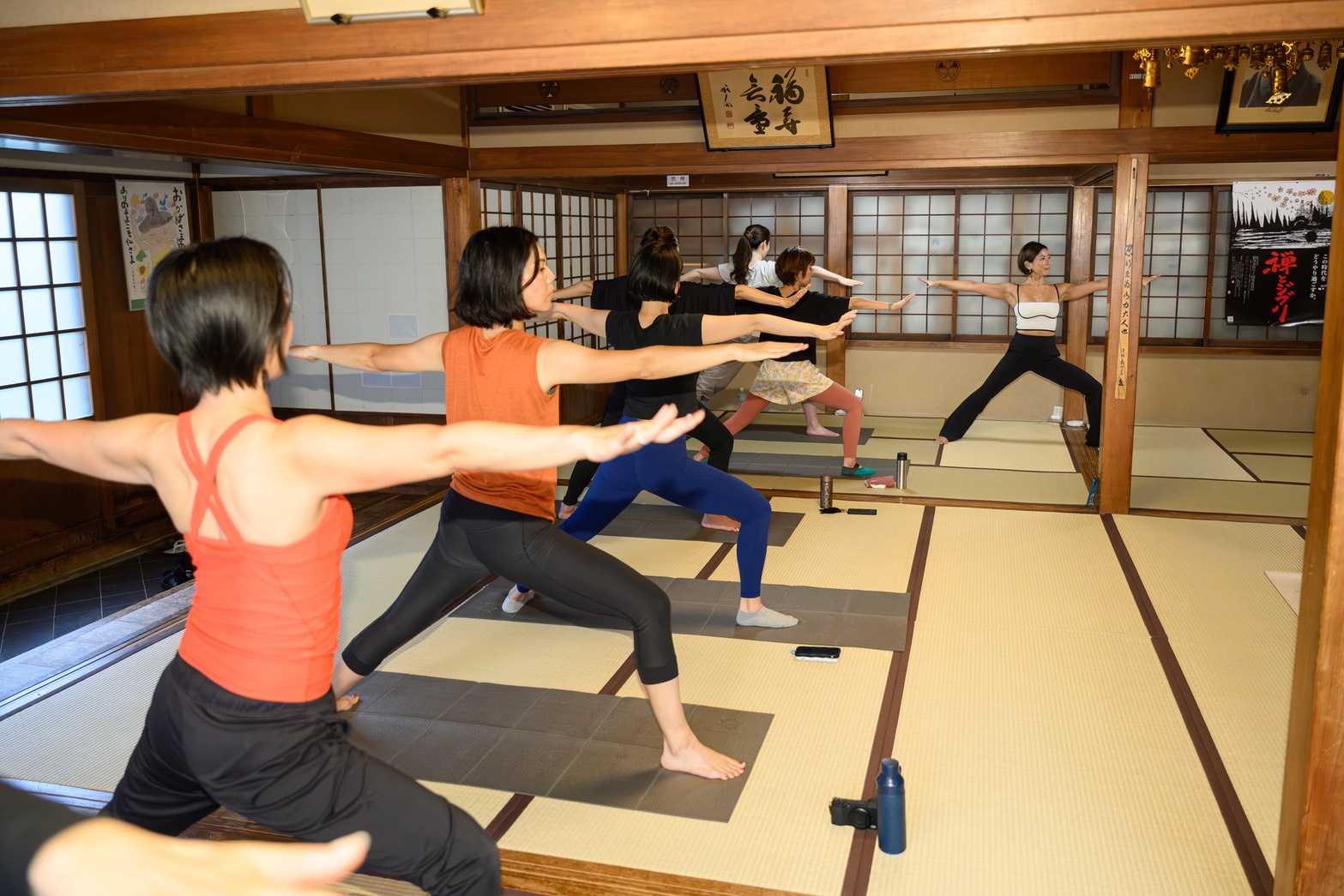 Group practicing Warrior II pose during Temple Yoga in Asakusa